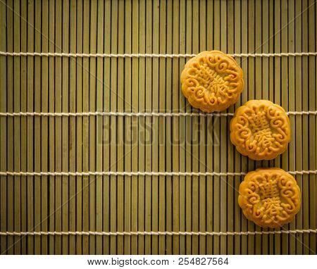 Traditional mooncakes is offered to friends or family during Mid-Autumn Festival. Flatlay on table, top down view low light with copy space. The Chinese character represent 