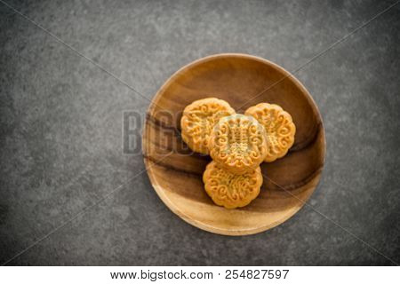 Traditional baked moon cakes is offered to friends or family during Mid-Autumn Festival. Flatlay on table top down view dark background with copy space. The Chinese character represent 