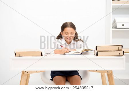 Excellent Pupil. Girl Child Writes Hometask While Sit Table White Background. Schoolgirl Studying Wr