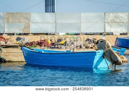 A Blue Boat On Jebha Harbor In Summer