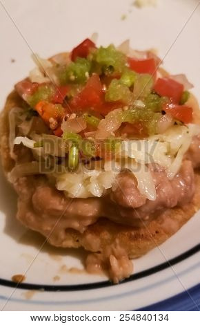 Sopes, A Traditional Mexican Dish. Onion, Jalapeno Pepper, Beans, Green Or Verde Sauce, Cheese, Toma