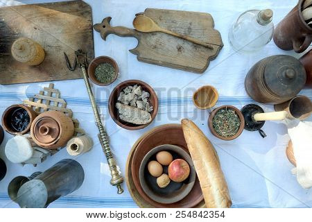 Still Life With Rural Repast Of Antique French Wooden And Metal Utensils, Vintage Scales And Simple 