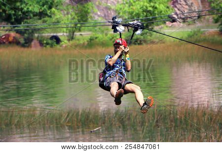 Banting, Selangor, Malaysia - July,28, 2018 : Men Enjoying Zip-line Flying Over The Forest At Tadom 