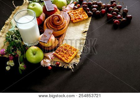 Homemade Cinnamon Buns In Glaze On A Dark Plate With Berries