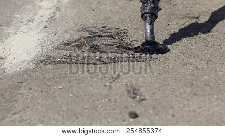 Workers Repair The Road, Pour Small Cracks With Bitumen To Prevent Further Destruction Of The Road S