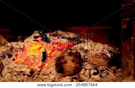 Burning Coals In The Fireplace On A Blurred Background, The Texture Of The Flame