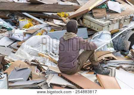 A Worker Resting After Loading Up Reavation Rubble From Outside An Office Block