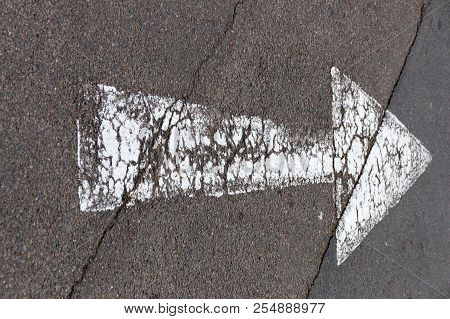 A Close Up View Of A White Painted Road Arrow Showing Direction Of Traffic