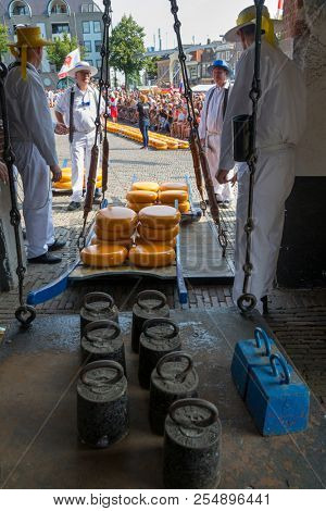 Alkmaar, Netherlands - July 20, 2018: Cheese carriers waiting for the cheeses to be weighted on the scale in the Waag building before being sold on the market