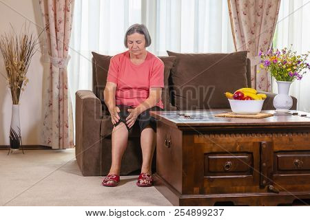 Elderly Woman Suffering From Pain In Knee At Home. Old Age Health Problem And People Concept Senior 