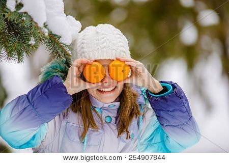 Girl And Tangerines. Cheerful Teen Girl Holding Oranges Near The Face. Healthy Girl With Vitamins In