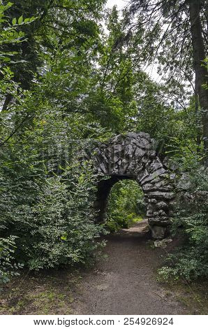 View Of Old Abandoned Rockery And Stone Arch Brushy With Various Plant In The  Natural Old West Park