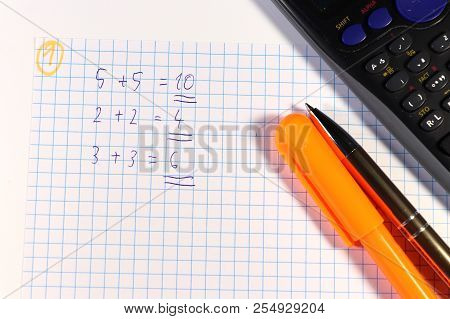 A Few Arithematical Problem On Square Paper. We Need Also Calculator And Felt Tip Pen. White Backgro