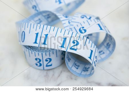 Measurring Tape Metter With Blue Figures Over Marbble Background. Control Weight, Loose Weight. Isoa