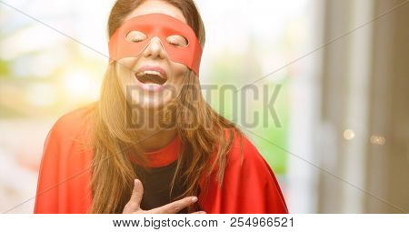 Middle age super hero woman wearing red mask and cape confident and happy with a big natural smile laughing