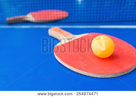 Pingpong Rackets And Ball And Net On A Blue Pingpong Table