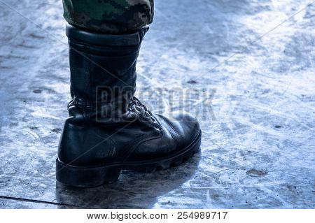 Army / Navy Military Boot With Jungle Camouflage Pants In Top Boot Standing On Dirty Polished Cement