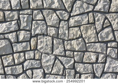 Decotative Stone Wall From Pieces Of Stone, Background.