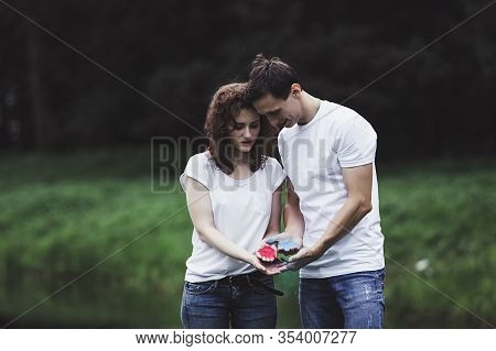Young Couple Holding Colorful Powder In Hands At Holi Festival