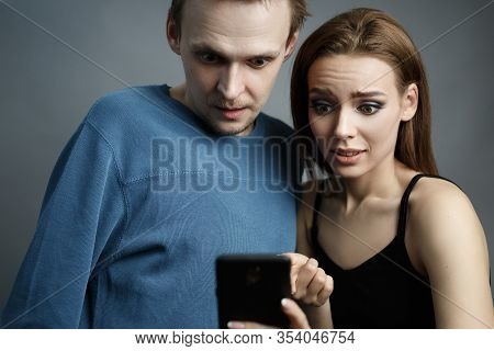 Man With Pretty Woman Is Looking At Something Interesting On A Smartphone They  Excitedly Looking At