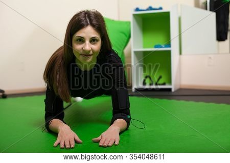 A Young Woman Doing Fitness Exercises In An Ems Suit. Concept: Health, Ems Training, Fitness In Ems 