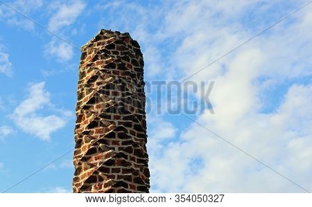 Tudor Barley Sugar Twist Red Brick Chimney Pot With A Blue Sky With White Cloud Background.