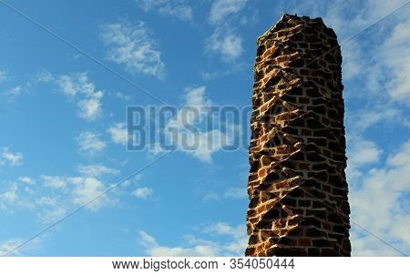 Tudor Barley Sugar Twist Red Brick Chimney Pot With A Blue Sky With White Cloud Background.