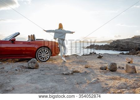Woman Enjoying Beautiful Oceanlandscapes, Traveling By Car On The Rocky Coastline During A Sunset, S