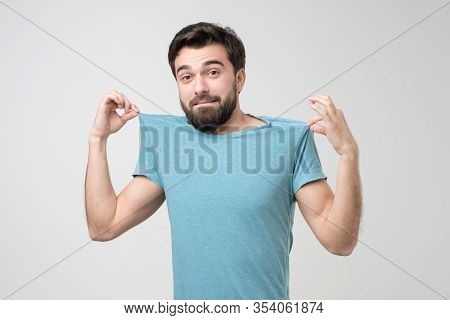 Man Smiling Joyfully And Pleased While Bragging With His New Blue T-shirt