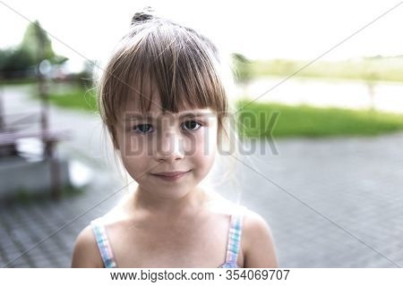Close-up Portrait Of Pretty Young Little Blond Pale Unhappy Moody Friendless Child Girl Looking Sadl