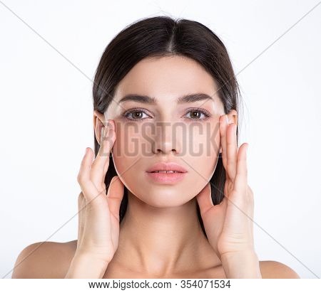 Portrait of beautiful young brunette woman with clean face. Beautiful face of young adult woman with clean fresh skin - isolated on white. Front portrait of woman with beauty face. Beauty concept 