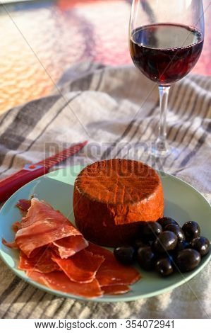 Tastes Of Spain, Jamon Iberian, Black Olives, Manchego Cheese With Red Paprika And Glass With Red Ri
