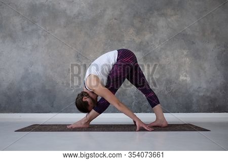Woman Practicing Yoga, Standing In Parsvottanasana Pose On Mat, Pyramid Exercise