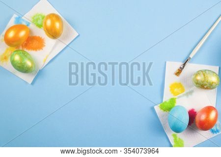 Only Painted Eggs Of Rakh Flowers With A Gold Dusting Dry On Napkins Next To A Brush On A Blue Backg