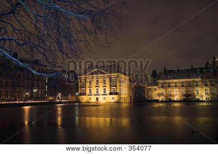 El Mauritshuis desprende De Hofvijver en la haya por la noche, cubierto por la nieve.