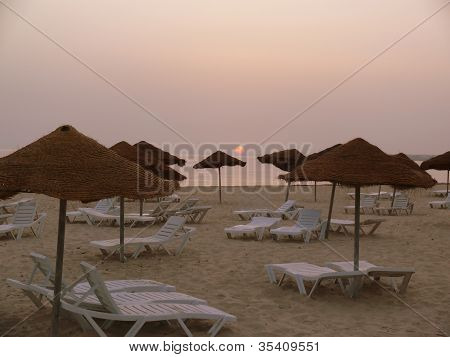 Solen stiger över en cafébar strand