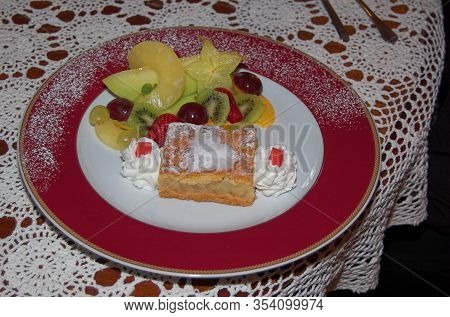 Beautifully Served Tasty Dessert On A Large Plate On A Reto White Tablecloth With Fruit