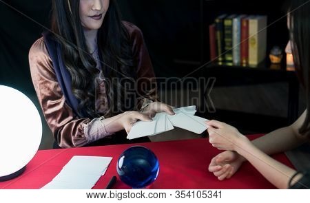 The Fortune-telling Woman Is Predicting The Fortune For A Beautiful Asian Woman By A Gypsy Card. It 
