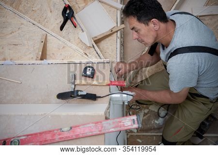 work in progress on stylish interior professional carpenter installing wooden stairs in big modern two level luxury apartment