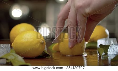 Male Hand Cutting Lemon Into Wedges