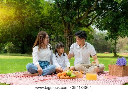 Asian Teen Family Happy Holiday Picnic Moment In The Park With Mother And Daughter Looking At Father
