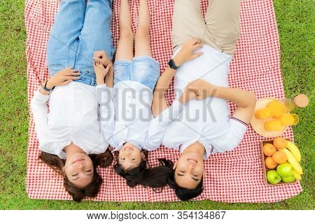 Asian Teen Family Happy Holiday Picnic Moment In The Park With Father, Mother And Daughter Lying On 