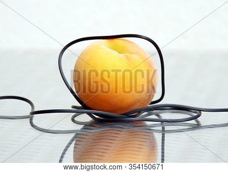 Delicious Ripe Peach And Thin Electrical Headphones Wire Against A High Key Background With Amazing 