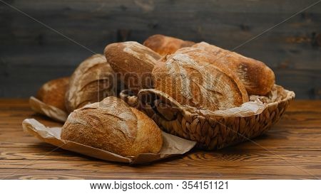 Different Buns Of Fresh Bread On A Brown Vintage Background. Freshly Baked Wheat Bread, Still Life W