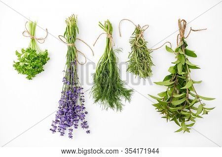 gardening, ethnoscience and organic concept - bunches of greens, spices or medicinal herbs on white background