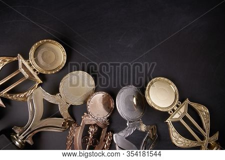 Golden trophy over blackboard background. top view. flat lay.Trophy is a specific achievement, serves as recognition / evidence of merit, awarded for sporting events
