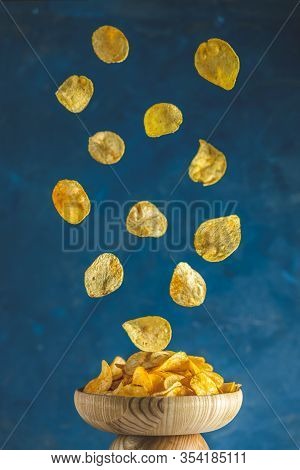 Tasty Potato Chips Falling Into Blow, Frozen In The Air. Color Of 2020 Year. Classic Blue, Food Tren
