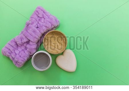 Purple Headband, Cosmetic Cream, Scrub And Heart-shaped Soap Flat Lay