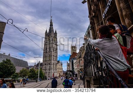 Ghent, Belgium, August 2019. The Bell Tower Called Beffroi Behind The Church Of St. Nicholas. A Tour