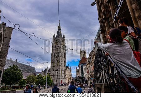 Ghent, Belgium, August 2019. The Bell Tower Called Beffroi Behind The Church Of St. Nicholas. A Tour